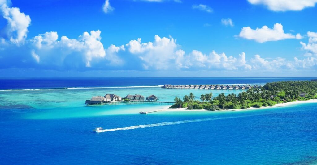 Crystal clear waters surround a luxurious Maldives resort under a bright blue sky.